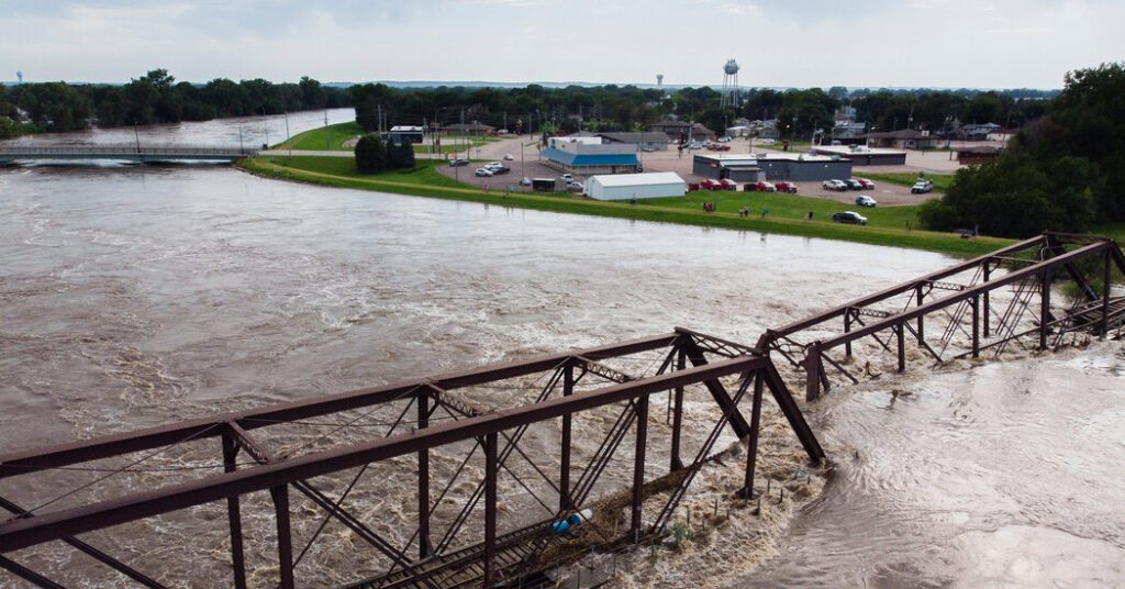 While Standing In Neck Deep Water In Iowa, A Husband Pleads